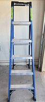 Front view of blue Louisville 6ft fiberglass ladder showing aluminum steps