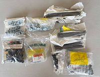 Overview of eight unopened packs of assorted hardware