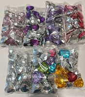 Six clear bags containing assorted colored heart-shaped gems
