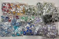 Multiple clear bags filled with multicolor faceted round gems