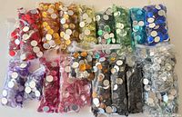 Bags of assorted coloured craft gems laid out flat