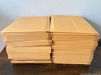 Two neat stacks of kraft padded mailers on table