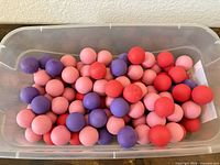 Bin with mixed light pink, red and purple 1" rubber balls