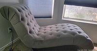 Full side view of tufted chaise lounge chair showing overall shape and upholstery