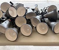 Group of 18 gray clamp LED spotlights on table