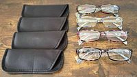 four soft black cases beside four pairs glasses