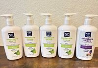 Front view of five Kiss My Face Moisture Shave bottles