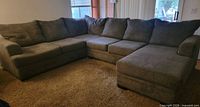 Full view of gray sectional sofa with chaise attached to right side