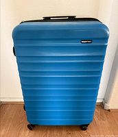 Front view of blue Amazon Basics suitcase