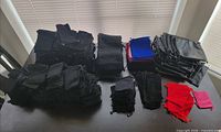 Stacks of assorted black, blue and red drawstring pouches laid out on table
