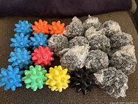 Assorted coloured spiky massage balls laid out; bubble-wrapped black balls visible