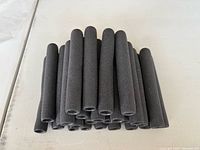 Stacked view of black foam grips showing length and open ends