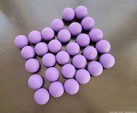 Thirty purple balls arranged in rows on tabletop