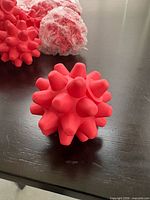 Single red spiky massage ball close-up showing spike shape and colour