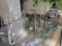 All three metal garden decor items on glass table
