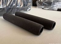 Pair of black foam grips showing overall shape and texture