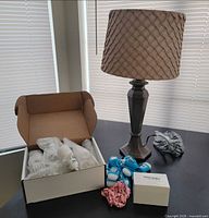 Lot overview showing lamp, open box of bulbs, sanitizer bottles, scrunchies, wheel box