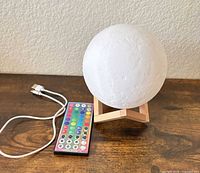 LED moon lamp on wooden stand with remote and charging cable