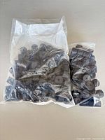 Two sealed bags containing numerous black rubber bumpers