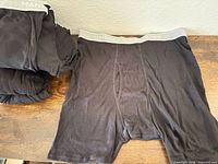 Stack of folded briefs and one unfolded showing front and waistband