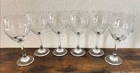 Front view of six clear wine glasses in a row