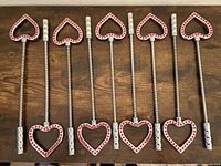nine metal heart wands jewel side facing, laid out on table