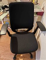 Front view showing seat, backrest, armrests and casters