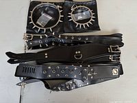 Group view of chrome steel collars in pouches and multiple faux leather collars