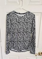 Front view of black/white Nike Dri-FIT Pronto Miler long sleeve top on hanger