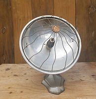Front view of silver parabolic reflector heater on base