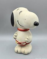 Full view of Snoopy plastic coin bank showing overall design and paint condition