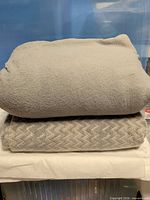 Two folded grey blankets stacked