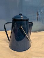 Full view of blue enamel coffee pot with lid and bail handle