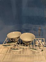 Two rice bowls, four fish rests, two shakers displayed on rack