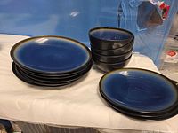 Stack of large dinner plates, bowls and smaller plates visible