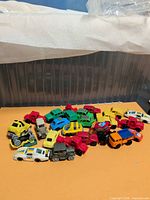Overall group of ~30 small Kinder Surprise cars and trucks on tabletop
