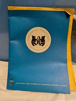 Front of blue and yellow Centennial folder