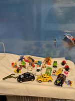 Group shot of all toy cars, figurines, accessories on white cloth