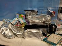 Group shot showing all silver bags, black organizers, cylindrical holder, power tap, gift boxes and packaged cords