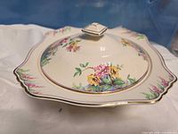 Lidded dish side view showing floral pattern and rim shape