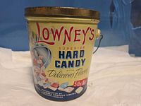 Front view of Lowney's 5 lb Superior Hard Candy tin with lid and handle visible
