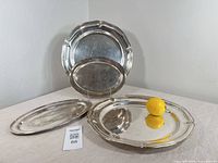 Group shot of all four silver-plate trays front and back for overall view and scale