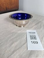 Angled side view of silver bowl with cobalt liner