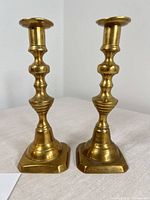Front view of both brass candlesticks standing upright