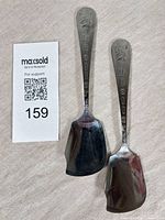 Two metal Dr Ballard’s scoops front view with embossed handles