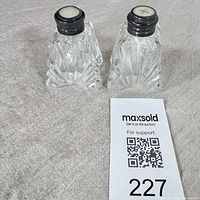 Both cut crystal shakers side by side showing overall form and mother of pearl tops