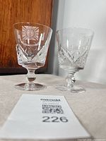Pair of etched Stuart crystal wine glasses on tabletop