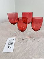 Front view of all four cranberry wine glasses upright