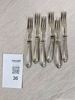 Six forks laid out showing fronts and handles