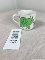 Mug side showing green polka-dot rhinoceros design